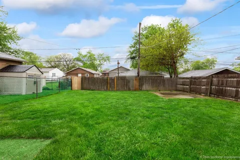 a view of a backyard with table and chairs and wooden fence