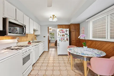 a kitchen with stainless steel appliances granite countertop a stove a sink dishwasher a microwave oven with a dining table and chair