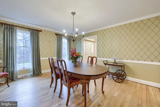 a dining room with furniture a chandelier and wooden floor