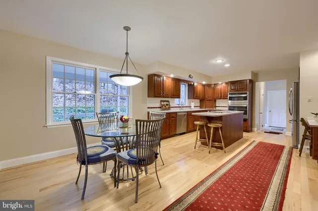 a dining room with furniture a chandelier and wooden floor