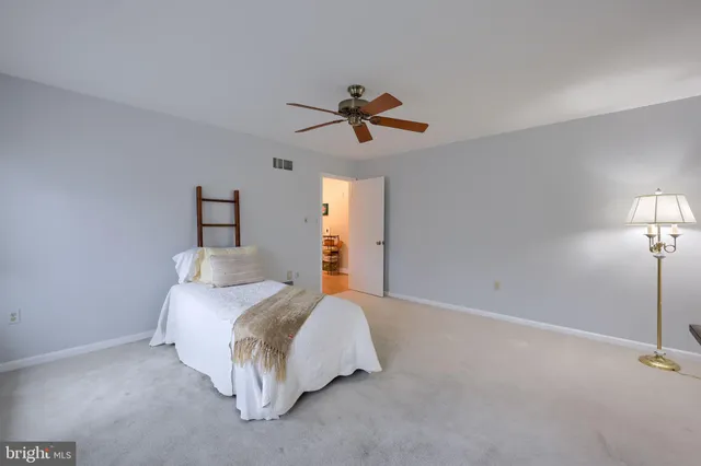 a bedroom with a bed chandelier and a window