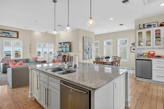 a kitchen with stainless steel appliances granite countertop a sink a stove and a wooden floors