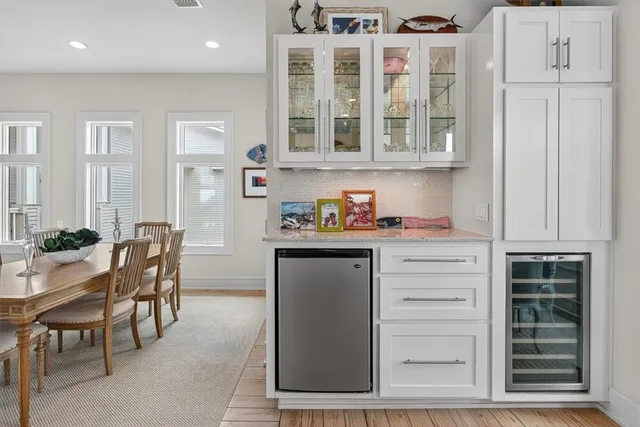 a kitchen with a white cabinets and chairs