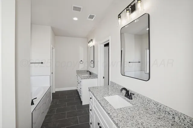 a bathroom with a granite countertop sink a mirror and shower