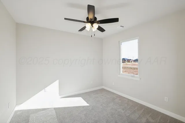 an empty room with a window and a fan
