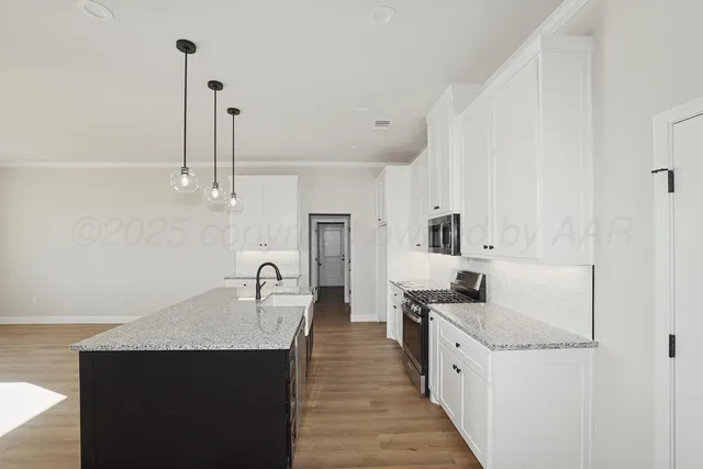 a kitchen with granite countertop a sink and cabinets