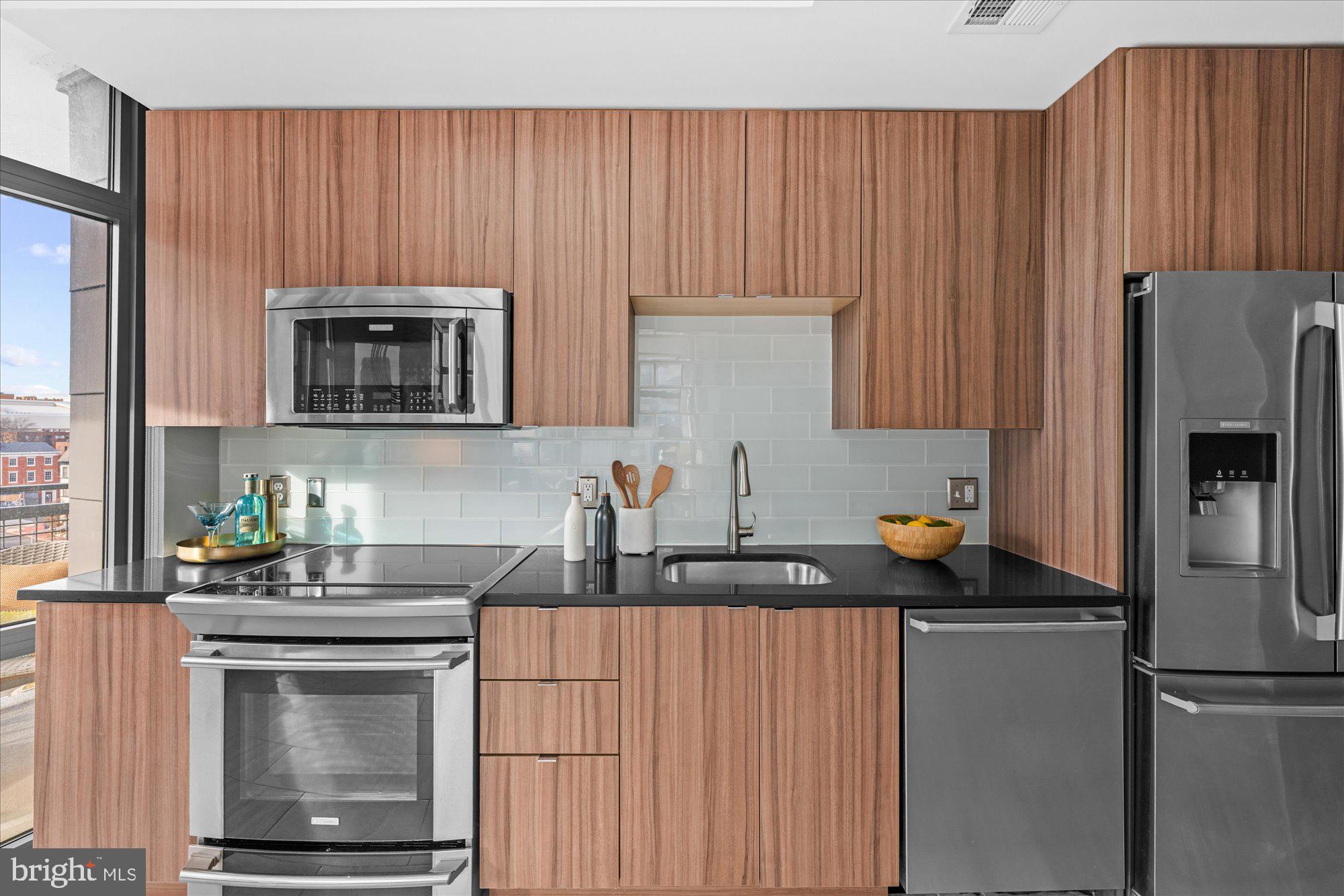 460 New York Avenue Northwest, Unit 504 Washington, DC 20001 - Photo 14 of 62 a kitchen with stainless steel appliances a stove a sink microwave and refrigerator