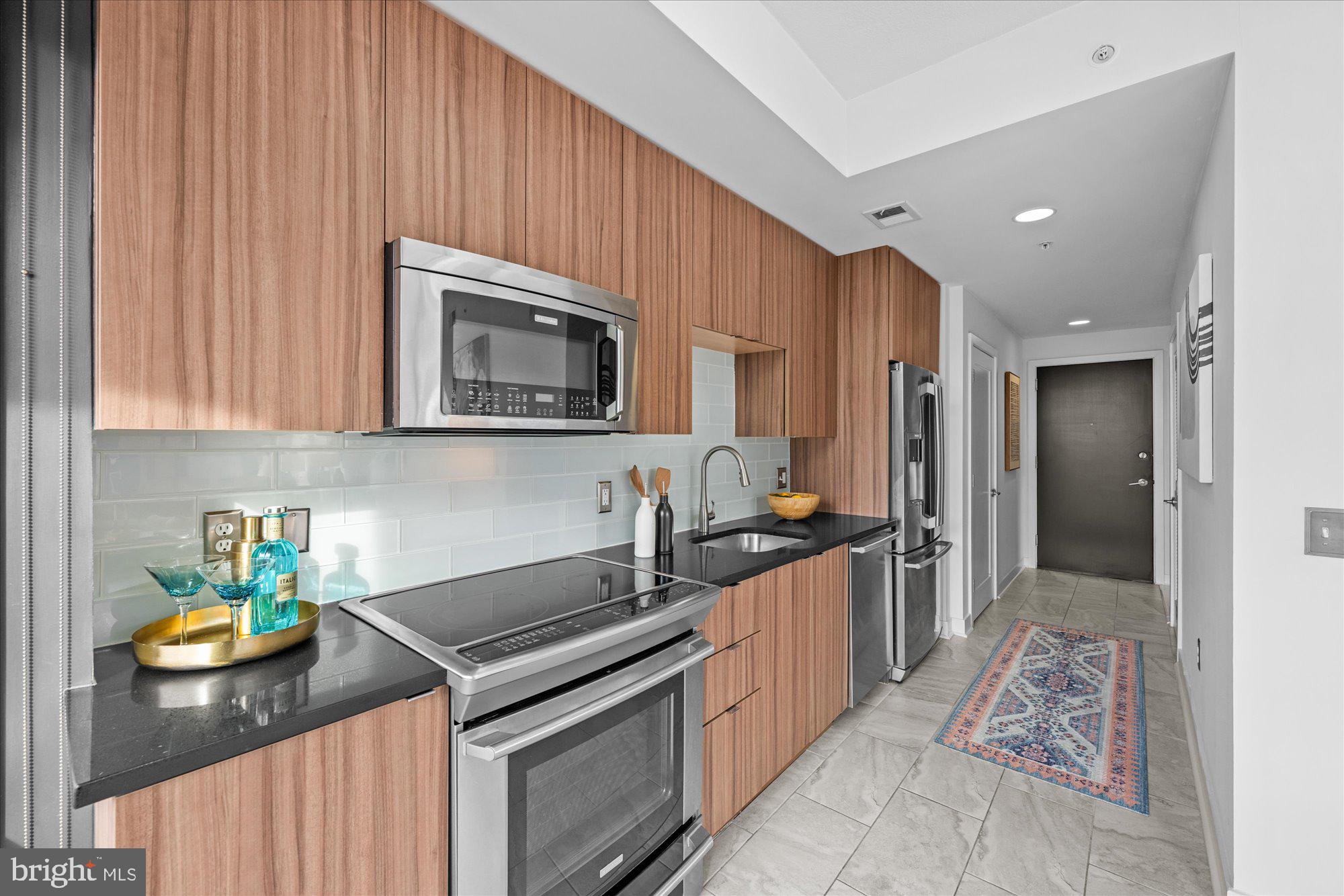 460 New York Avenue Northwest, Unit 504 Washington, DC 20001 - Photo 15 of 62 a kitchen with stainless steel appliances granite countertop a stove refrigerator and microwave