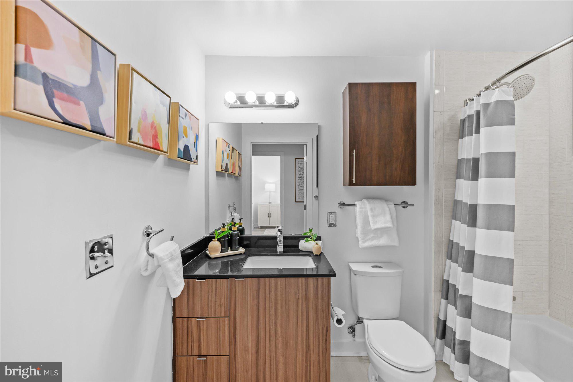 460 New York Avenue Northwest, Unit 504 Washington, DC 20001 - Photo 27 of 62 a bathroom with a sink a toilet and shower