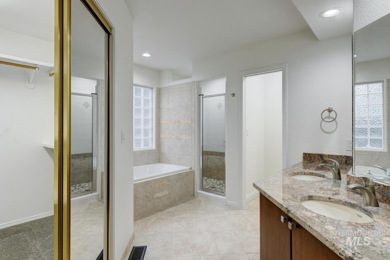 1168 North Pinnacle Way Eagle, ID 83616 - Photo 21 of 32 Master Bathroom with double vanity, granite counters, walk in shower,corner soaker tub, recessed lighting, and light tile patterned flooring