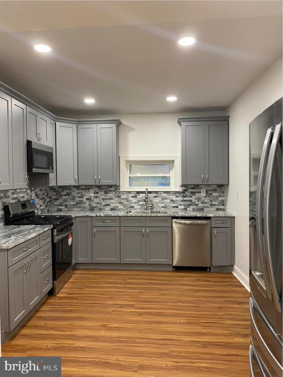 758 Fremont Street Lancaster, PA 17603 - Photo 6 of 20 a large kitchen with stainless steel appliances granite countertop a stove a sink dishwasher a refrigerator and white cabinets with wooden floor