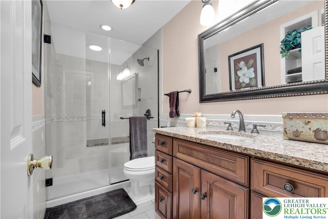 3830 McIntosh Drive Orefield, PA 18069 - Photo 21 of 36 a bathroom with a granite countertop sink a toilet a shower and a mirror