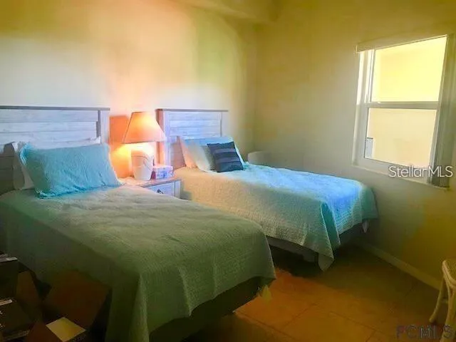 a bedroom with a bed and lamp next to a window