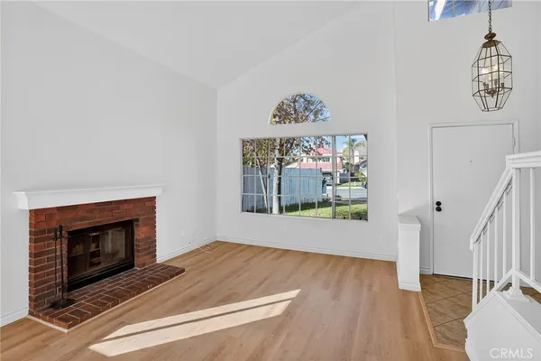 an empty room with wooden floor a fireplace and painted walls