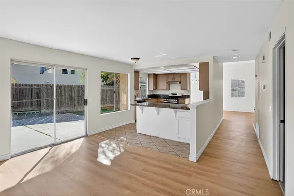 a large white kitchen with wooden floor and a large window