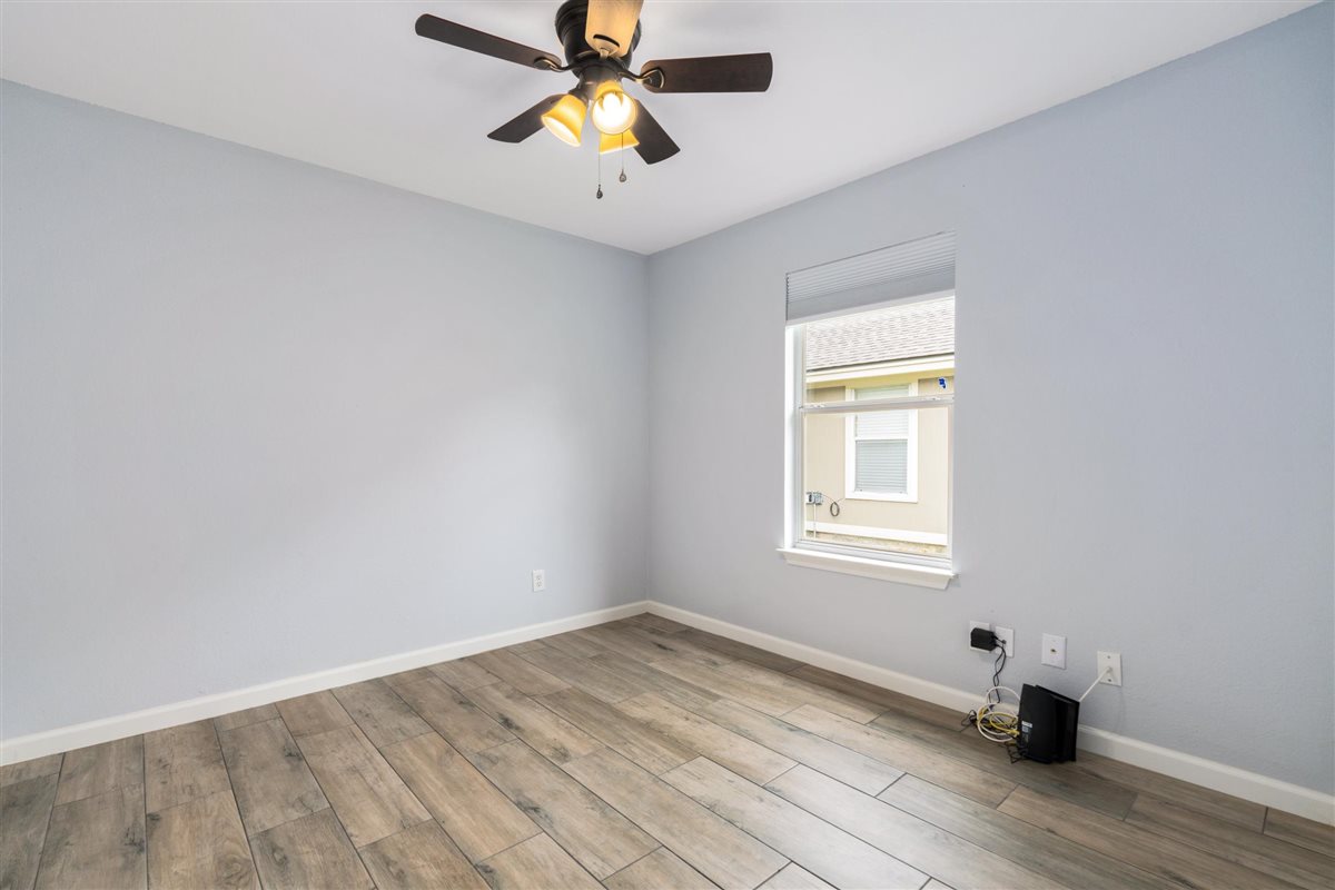 2147 Jasmine Path Round Rock, TX 78664 - Photo 26 of 36 Wood-look tile flooring runs through both rooms for a low-maintenance, cohesive look.
