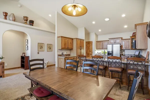 a kitchen with stainless steel appliances granite countertop a table chairs and a refrigerator