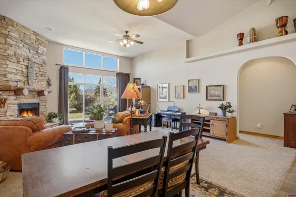 a kitchen with stainless steel appliances granite countertop a stove a refrigerator a kitchen island a table and chairs