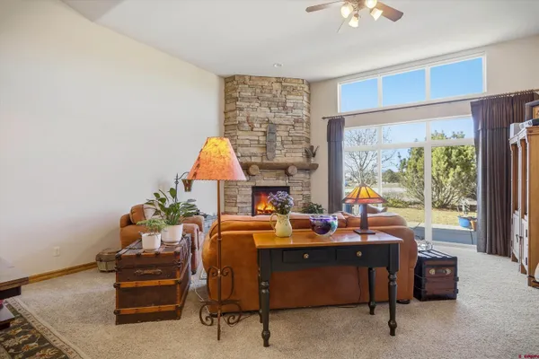 a living room with fireplace furniture and a kitchen view