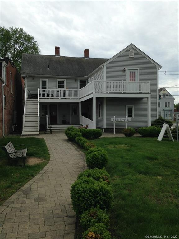 13 West Main Street, Unit 1 Clinton, CT 06413 - Photo 1 of 1 a front view of a house with a yard and trees