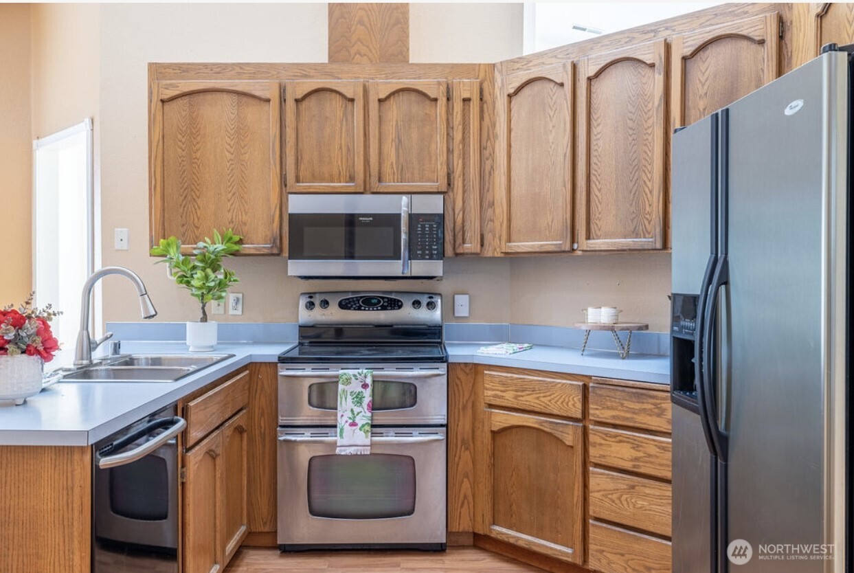 11209 Southeast 267th Place Kent, WA 98030 - Photo 15 of 27 a kitchen with stainless steel appliances granite countertop a stove a sink and a microwave
