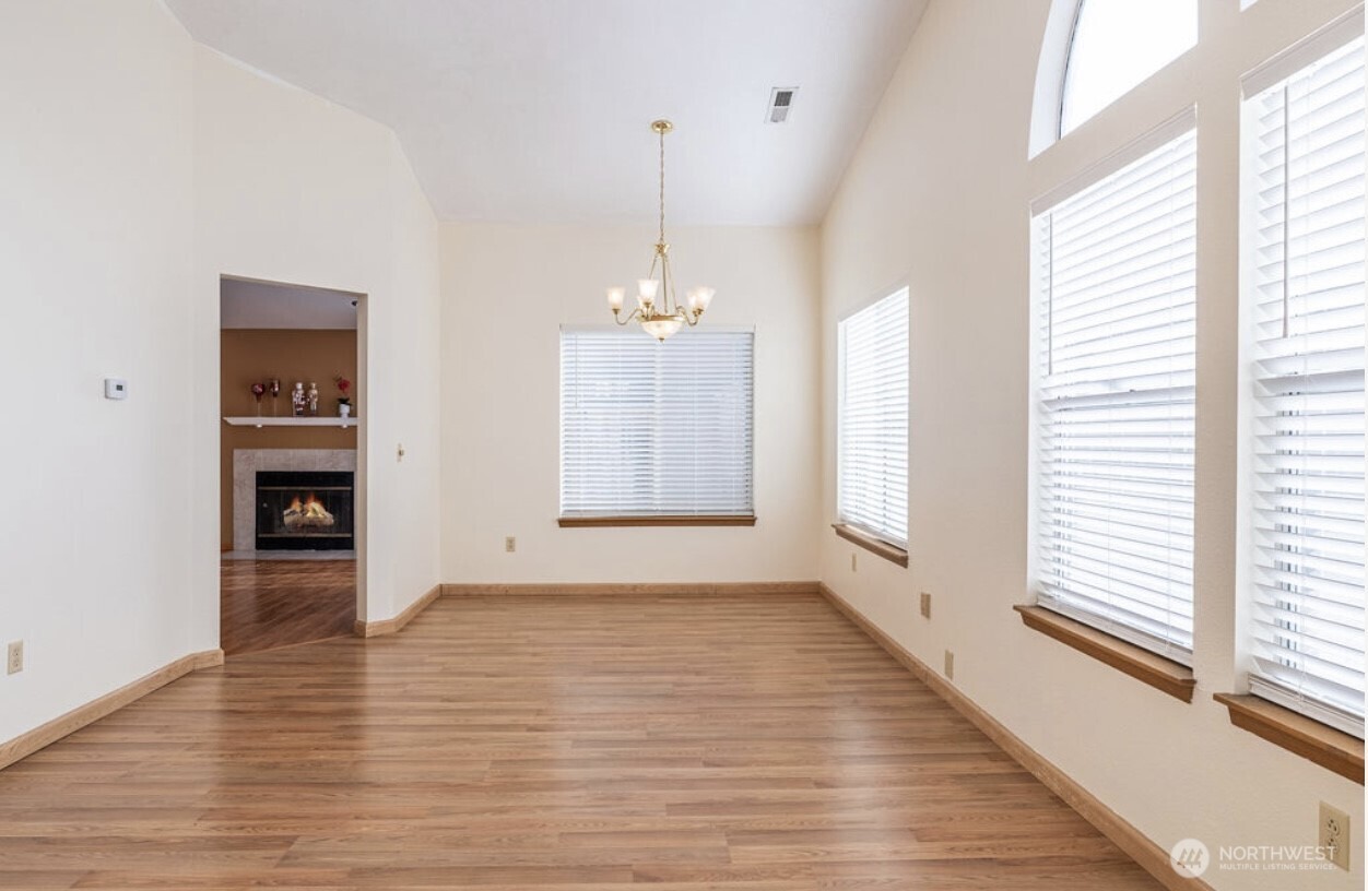 11209 Southeast 267th Place Kent, WA 98030 - Photo 7 of 27 a view of an empty room with window and wooden floor