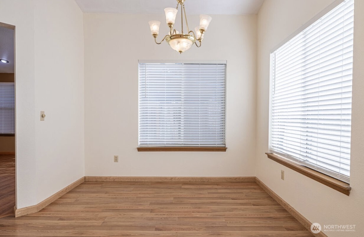 11209 Southeast 267th Place Kent, WA 98030 - Photo 8 of 27 a view of an empty room with wooden floor and a window