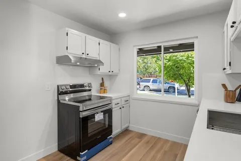 a kitchen with stainless steel appliances white cabinets and a window