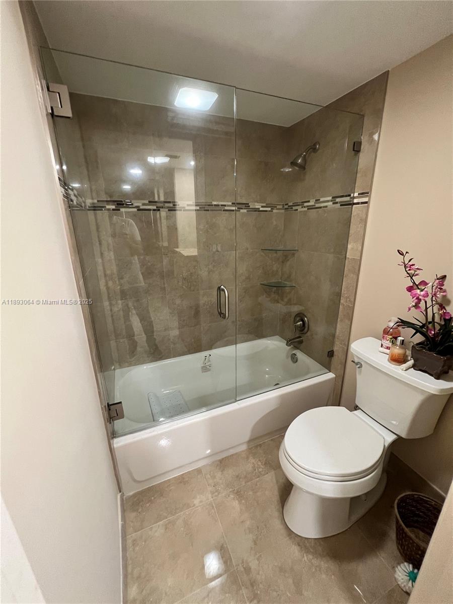 10777 West Sample Road, Unit 301 Coral Springs, FL 33065 - Photo 5 of 12 a white toilet and tub sitting next to a bathroom sink