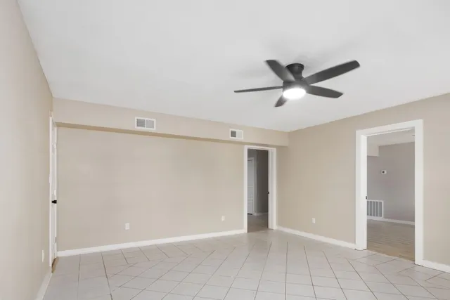 a bedroom with a large bed and a ceiling fan
