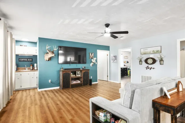 a living room with stainless steel appliances kitchen island hardwood floor and living room view