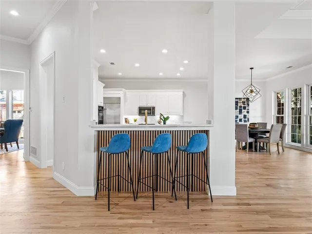 a view of kitchen with stainless steel appliances kitchen island granite countertop a table and chairs in it