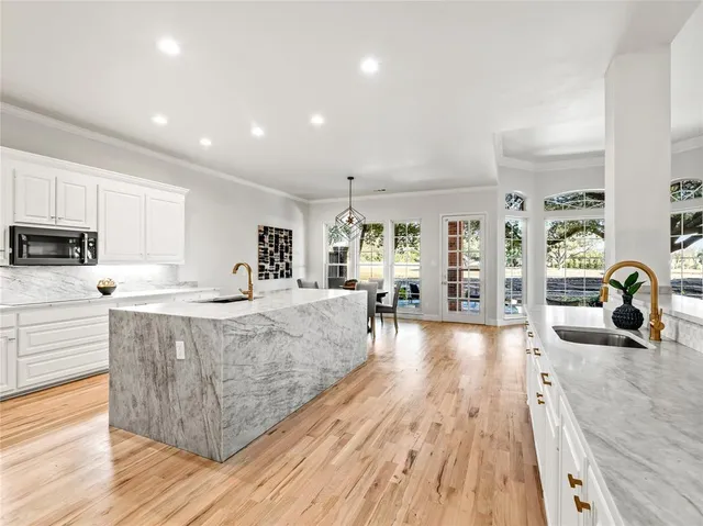 a large living room with stainless steel appliances granite countertop a couch and a wooden floors