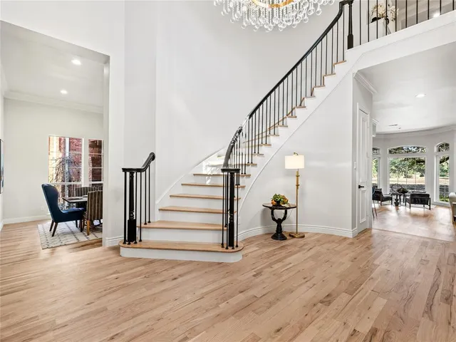 a view of a hallway with wooden floor and staircase