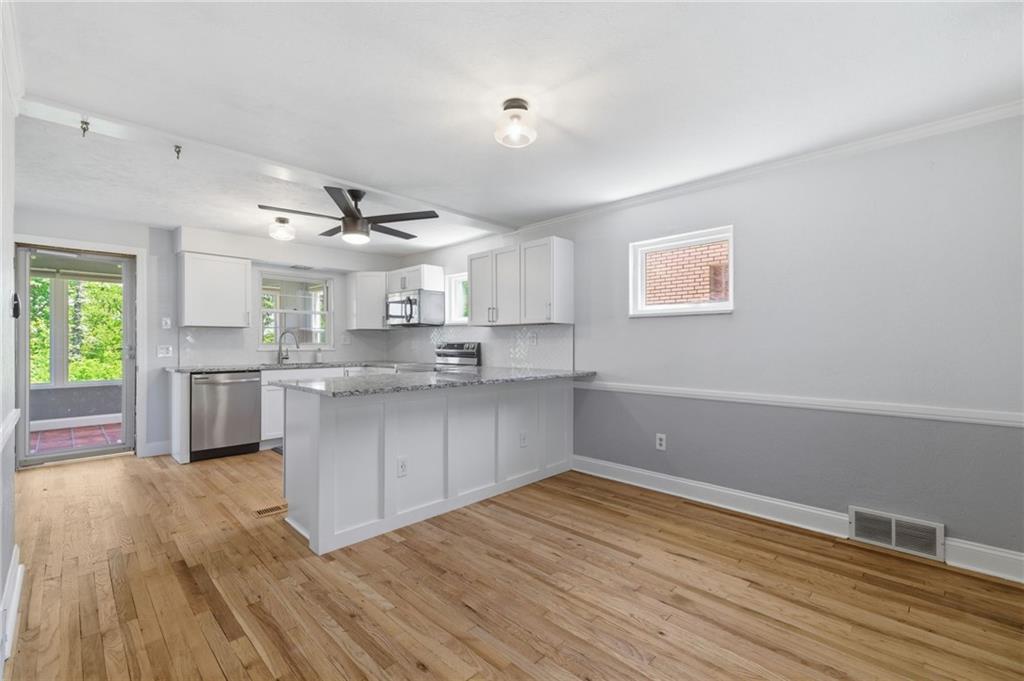 4883 East Willock Road Pittsburgh, PA 15227 - Photo 6 of 33 a kitchen with stainless steel appliances granite countertop a sink cabinets and wooden floor