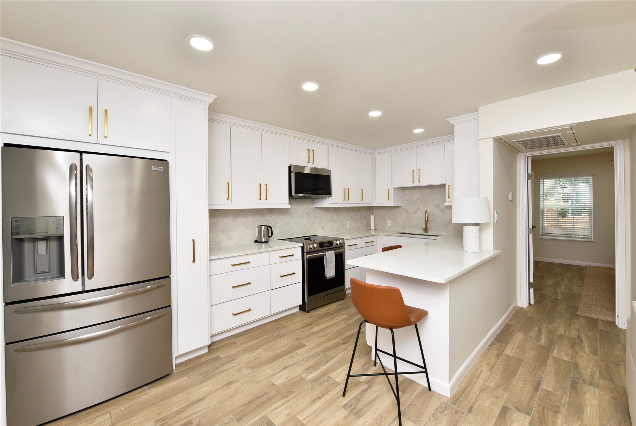 3224 Timmons Lane, Unit 112 Houston, TX 77027 - Photo 11 of 30 a kitchen with stainless steel appliances a refrigerator stove microwave and cabinets