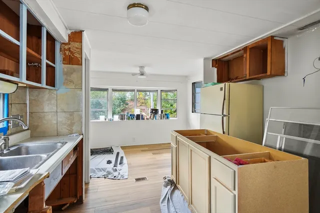 a kitchen that has a lot of cabinets in it and wooden floors