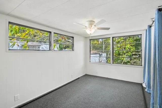 a view of a livingroom with a ceiling fan and window