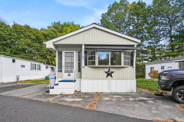 a view of a house with a large window and a car parked in front of it