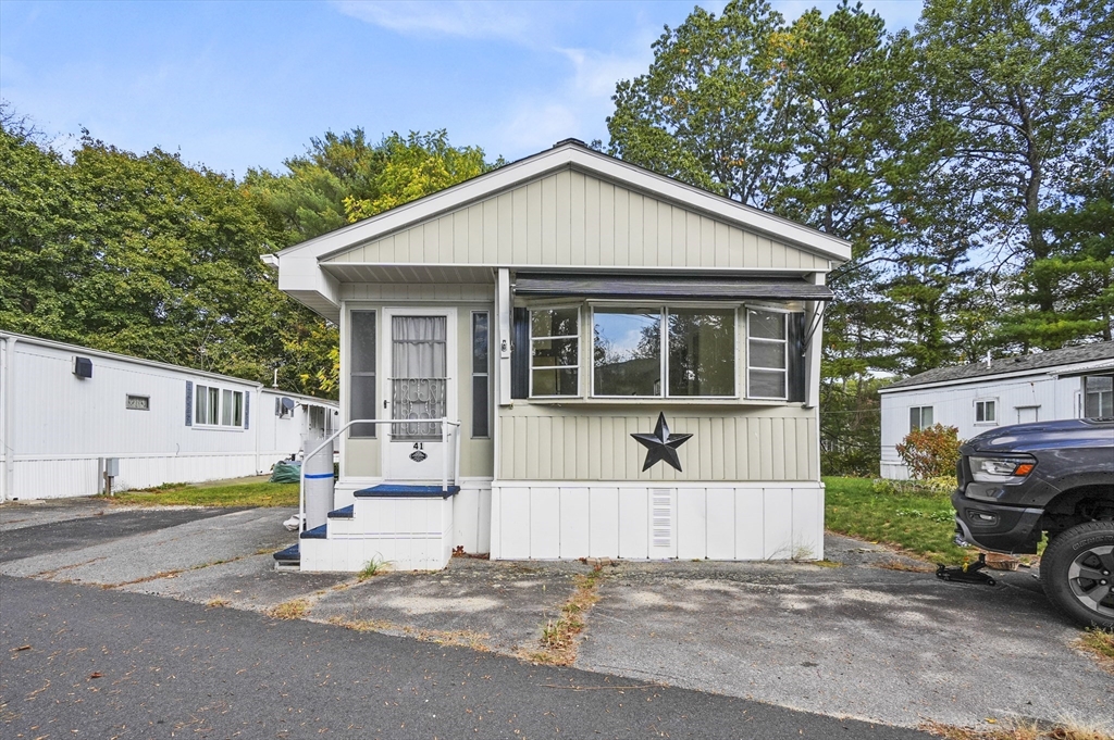 83 Clark Road, Unit 41 Shirley, MA 01464 - Photo 2 of 26 a view of a house with a large window and a car parked in front of it