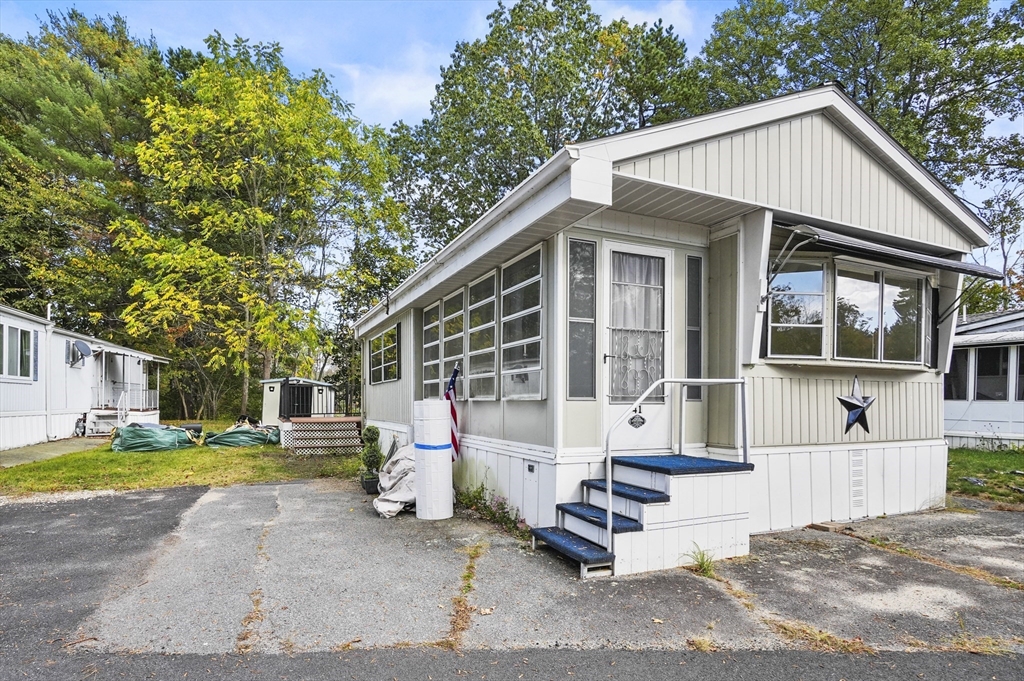 83 Clark Road, Unit 41 Shirley, MA 01464 - Photo 4 of 26 a view of a white house with swimming pool in front of it