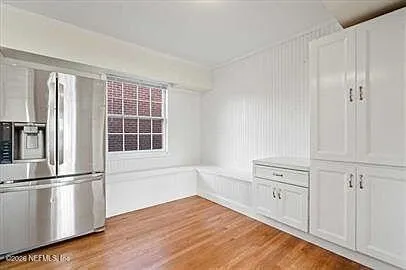 a view of empty room with wooden floor and cabinet