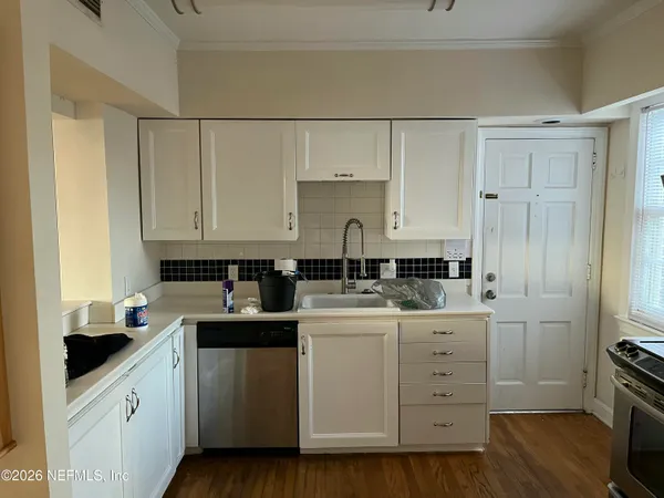 a kitchen with a sink cabinets and wooden floor