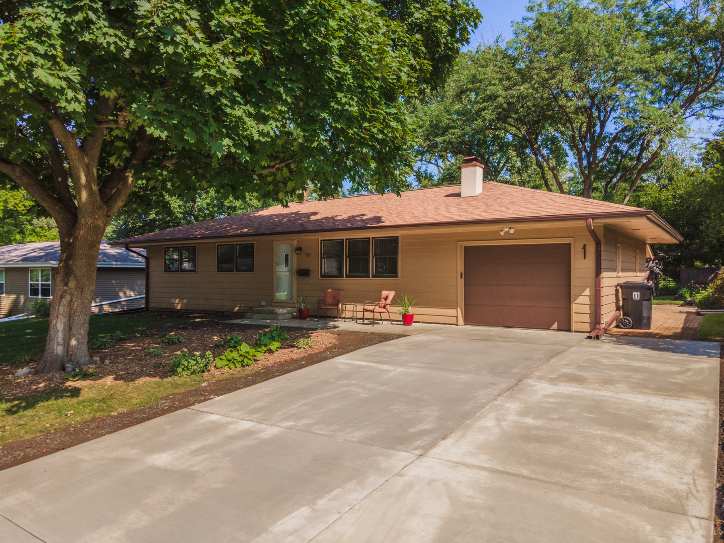 a front view of a house with a garden and trees