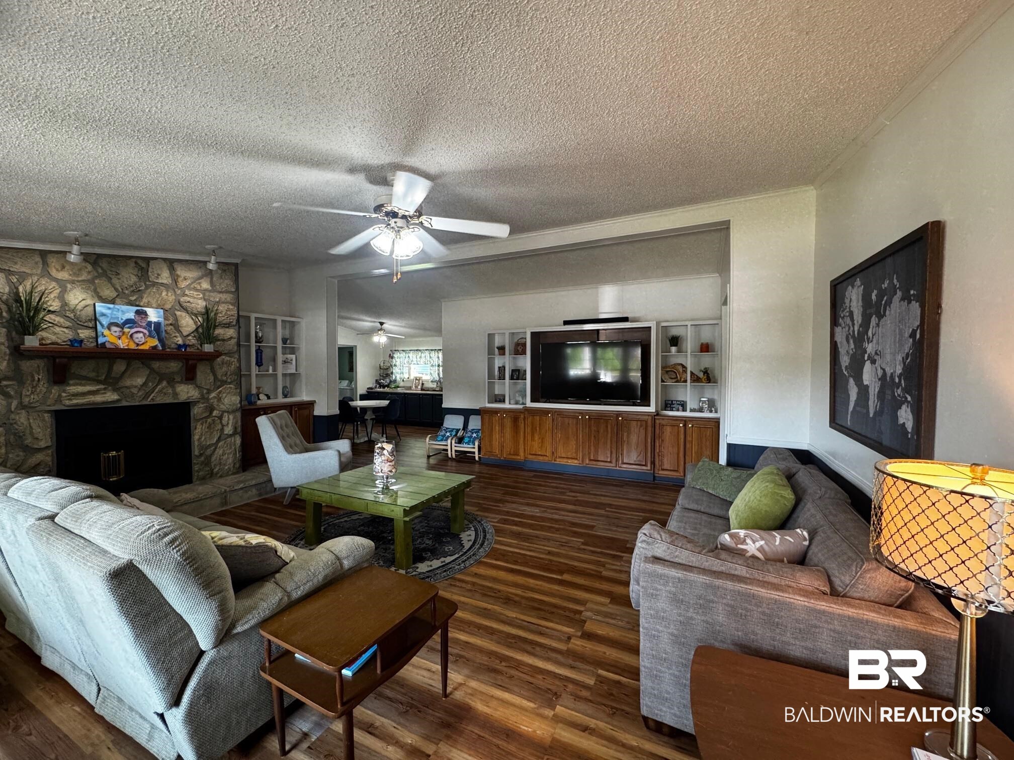 1882 Cisco Circle Lillian, AL 36549 - Photo 6 of 40 Living room featuring a fireplace, dark wood-style flooring, a textured ceiling, and a ceiling fan