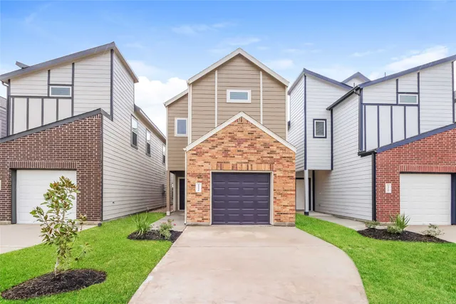 a front view of a house with a garden and plants