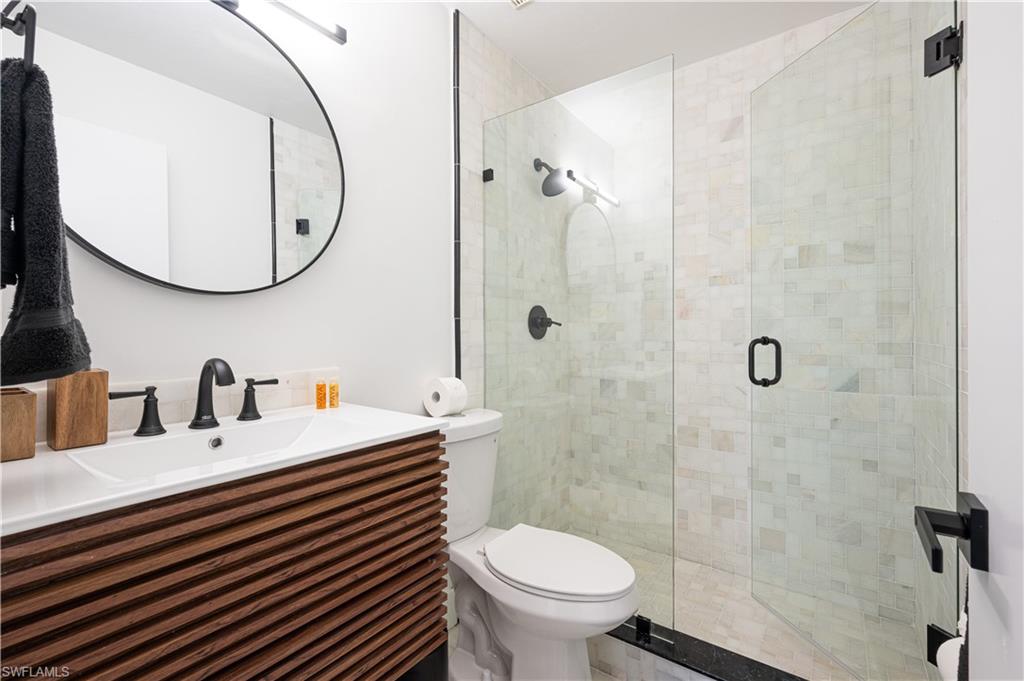 507 14th Street North Naples, FL 34102 - Photo 11 of 33 Bathroom with toilet, a shower with door, and vanity