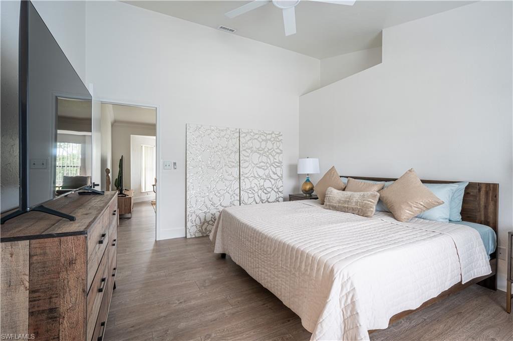 507 14th Street North Naples, FL 34102 - Photo 4 of 33 Bedroom with ceiling fan, a towering ceiling, and hardwood / wood-style flooring