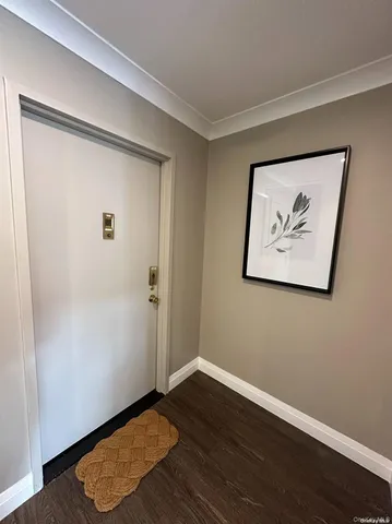 an empty room with wooden floor and window