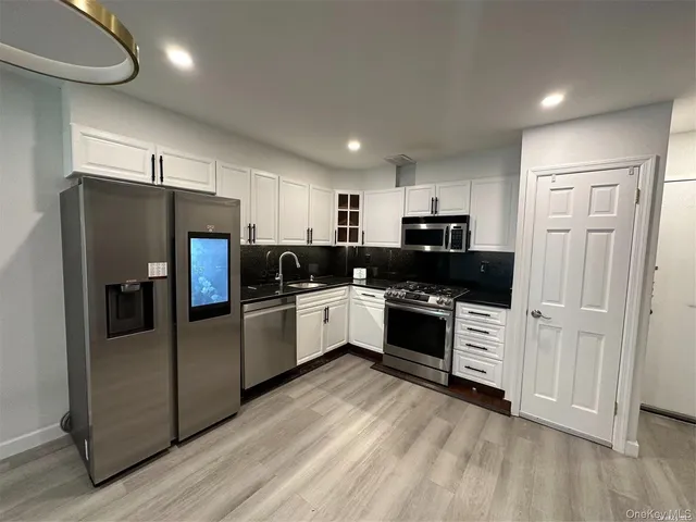a kitchen with stainless steel appliances and white cabinets